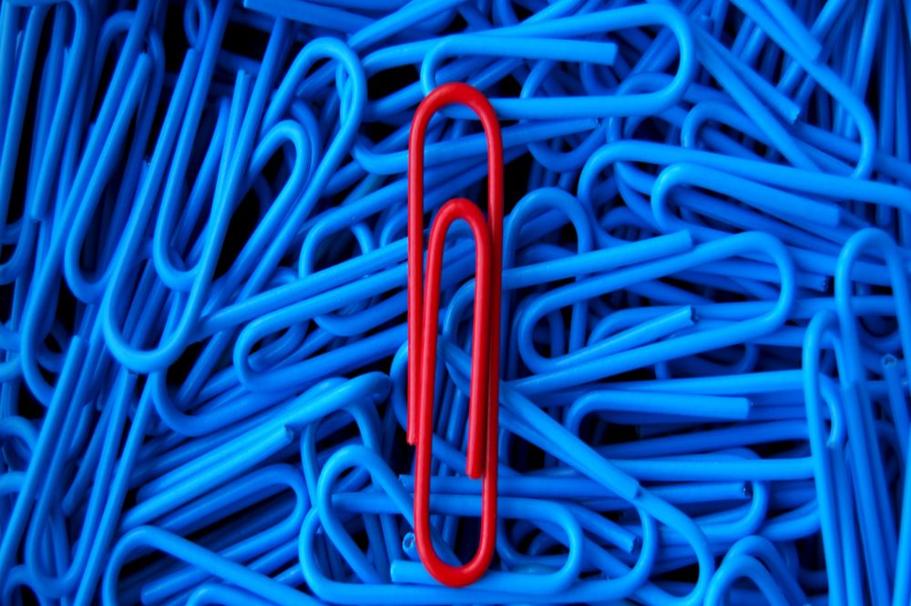 Photo of same color paperclips with one a different color